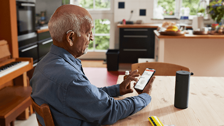 Oude man met telefoon in hand