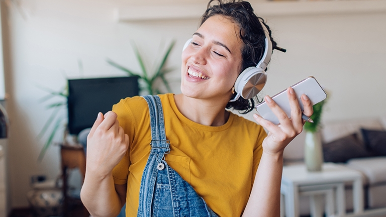 Vrolijke vrouw luistert muziek