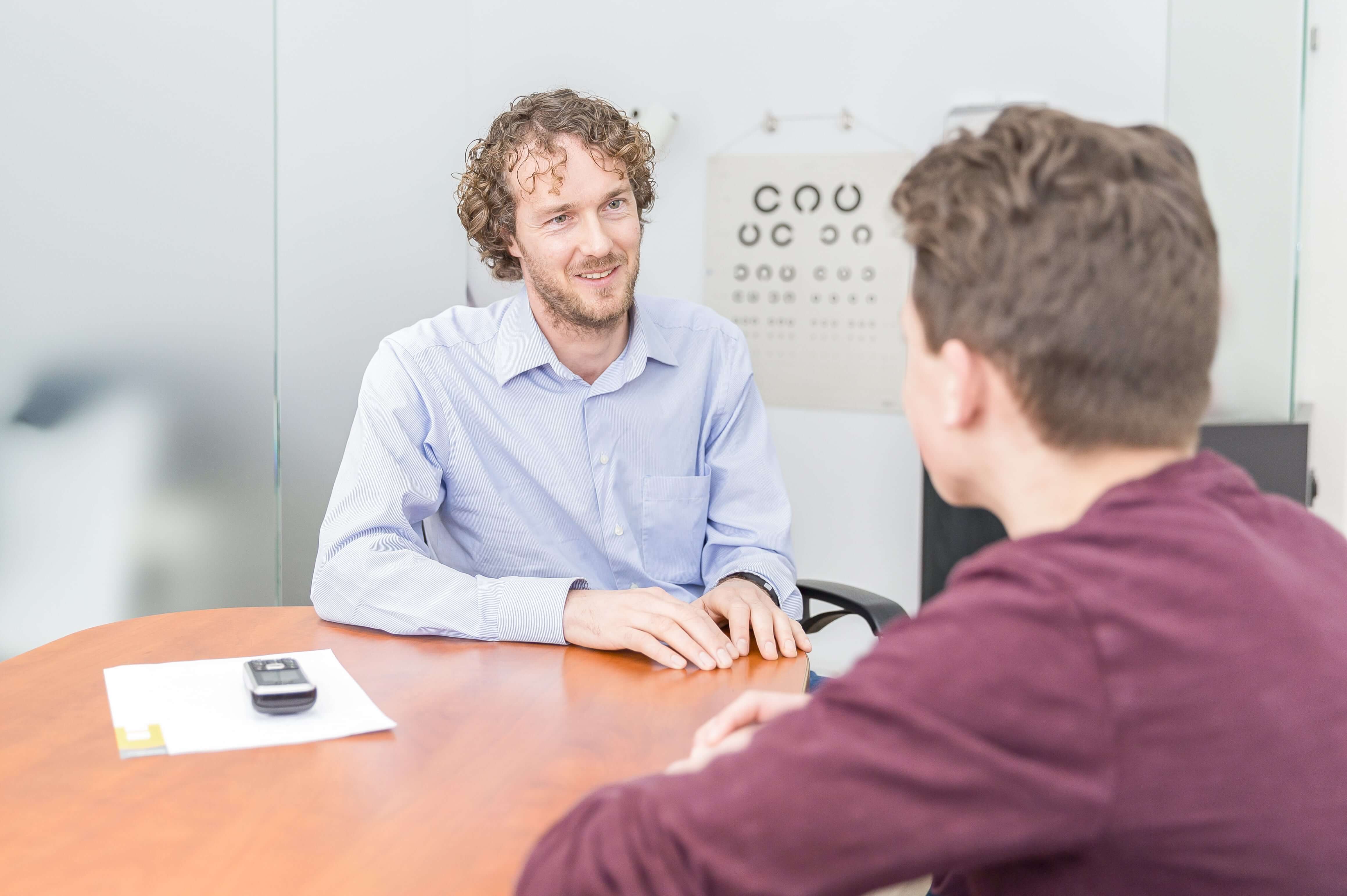 Beeld van een arts in gesprek met een jongen