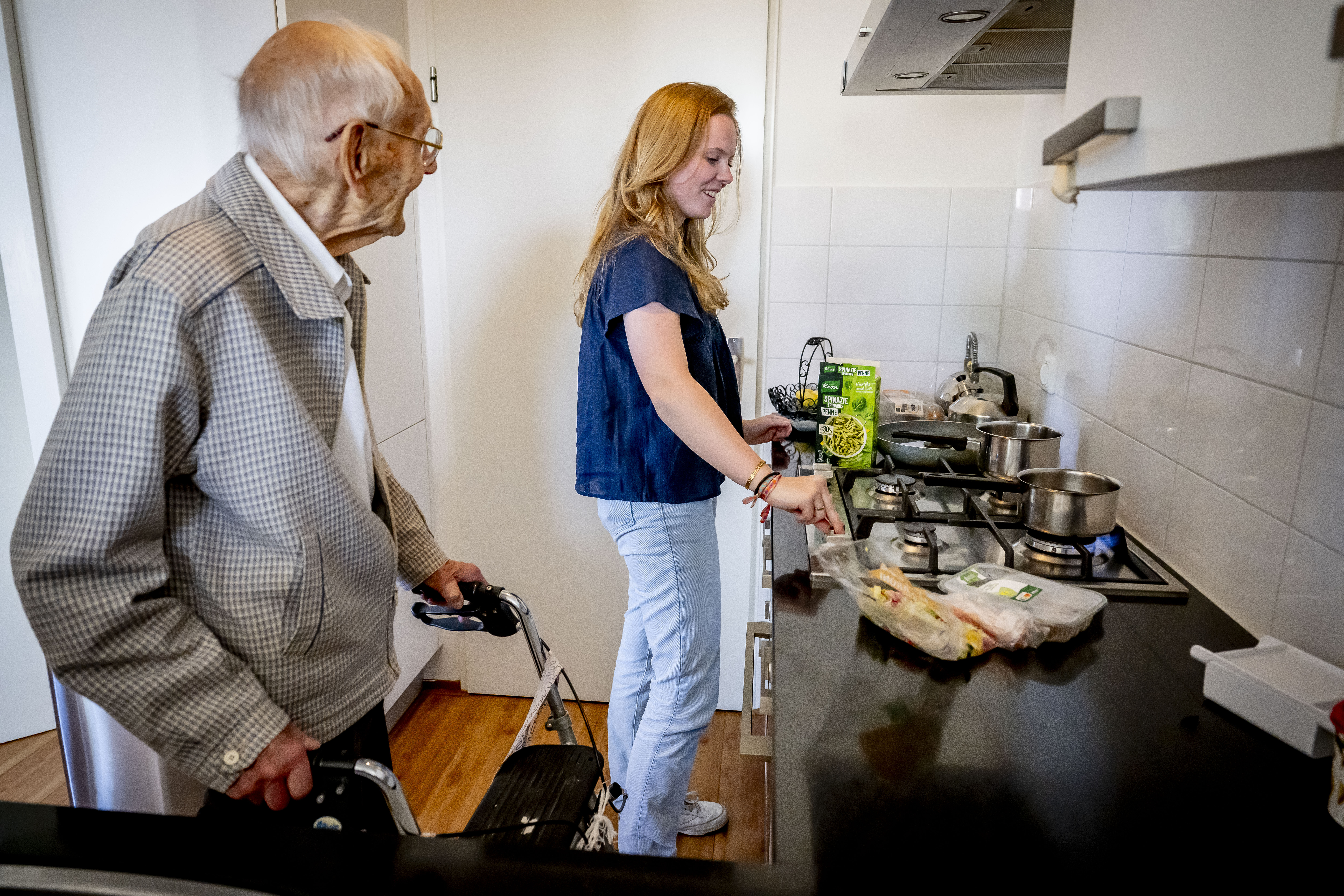 Vrouw helpt oudere man uit met koken