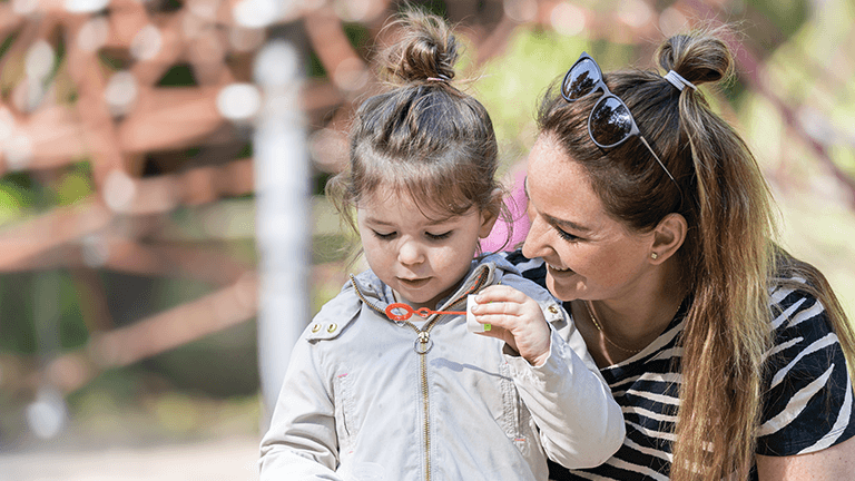 Vrouw met kind blaast bel