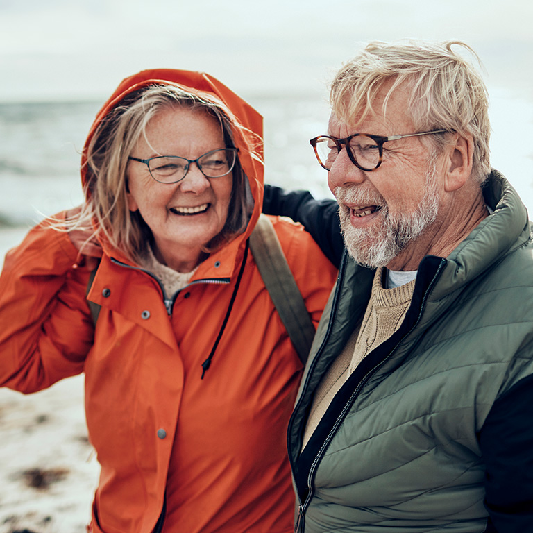 Twee gepensioneerden wandelen aan zee