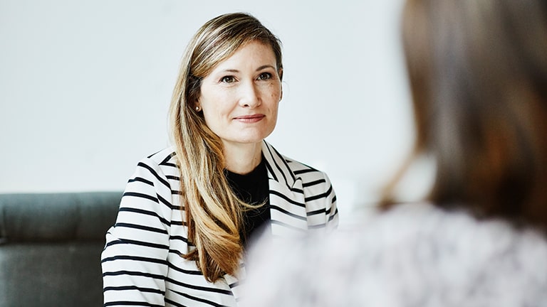 Vrouw voert gesprek op bank met andere vrouw