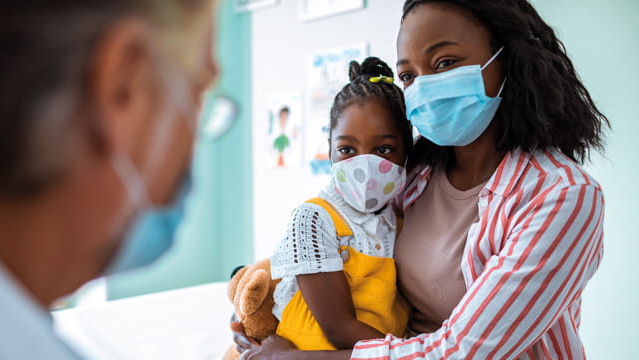 Vrouw en kind bij de dokter met mondkapje