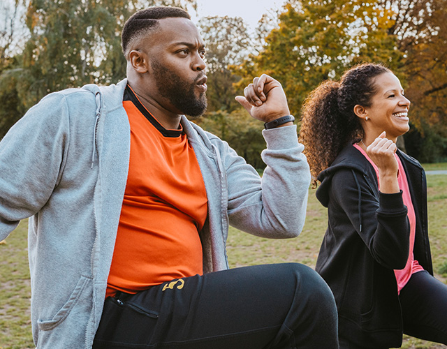 Man en vrouw doen sportoefeningen in het park