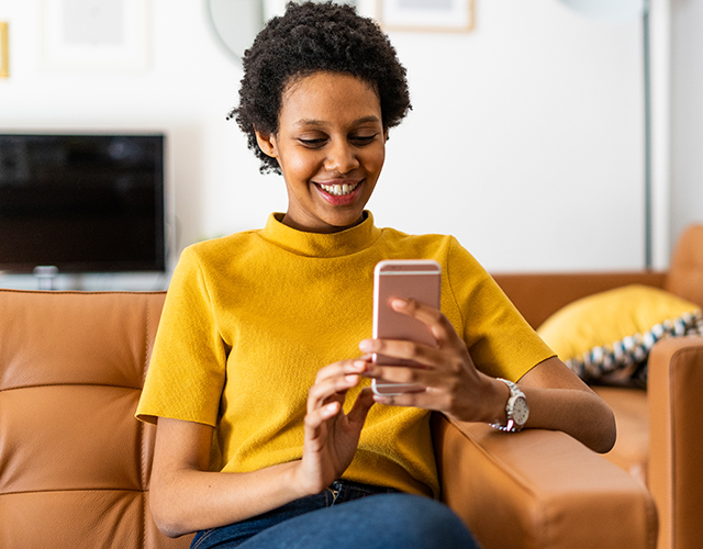 Vrouw op bank met mobiele telefoon