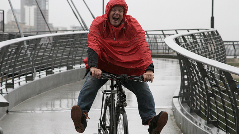 Vrolijke man op fiets op een brug