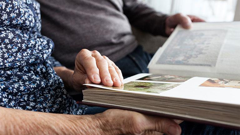 Ouderen bladeren samen door fotoboek