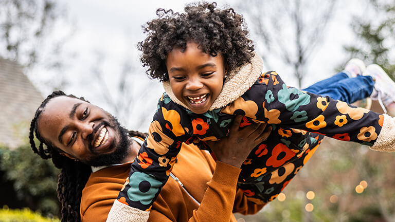 Vader laat kindje door de lucht vliegen