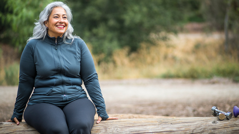 Vrouw geniet van omgeving op boomstam