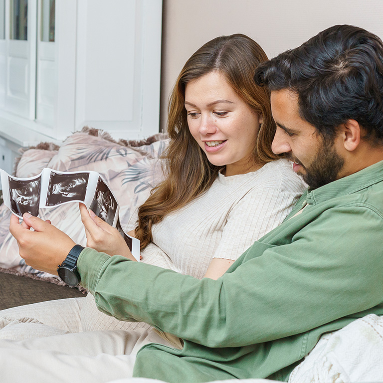 Man en vrouw op bank met echo foto's