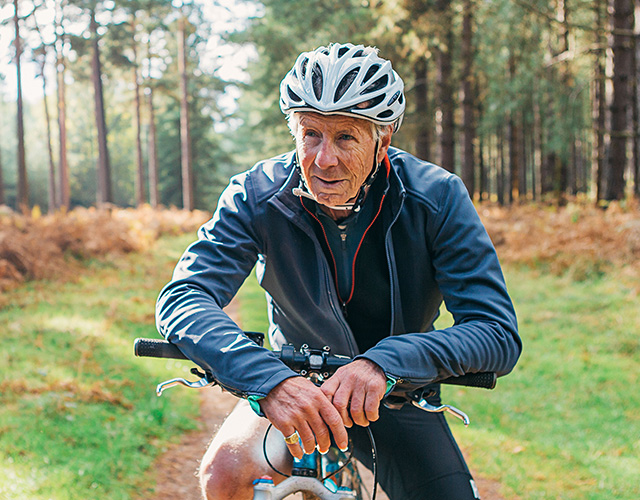 Senior man zit op een racefiets