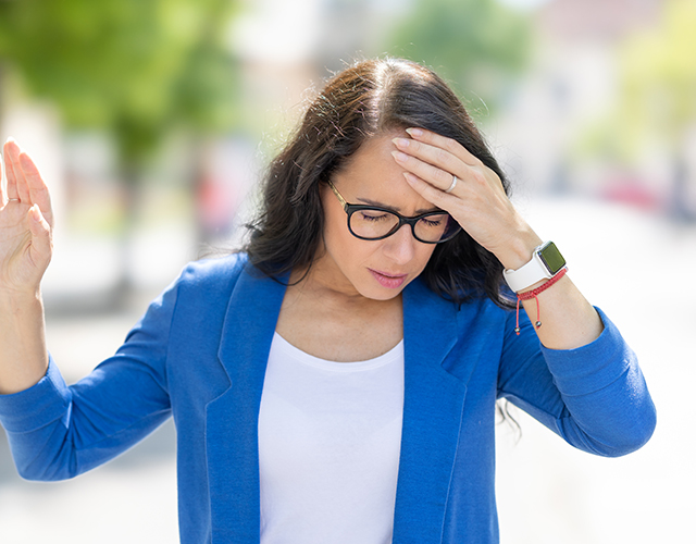 Vrouw houdt voorhoofd vast door duizeligheid
