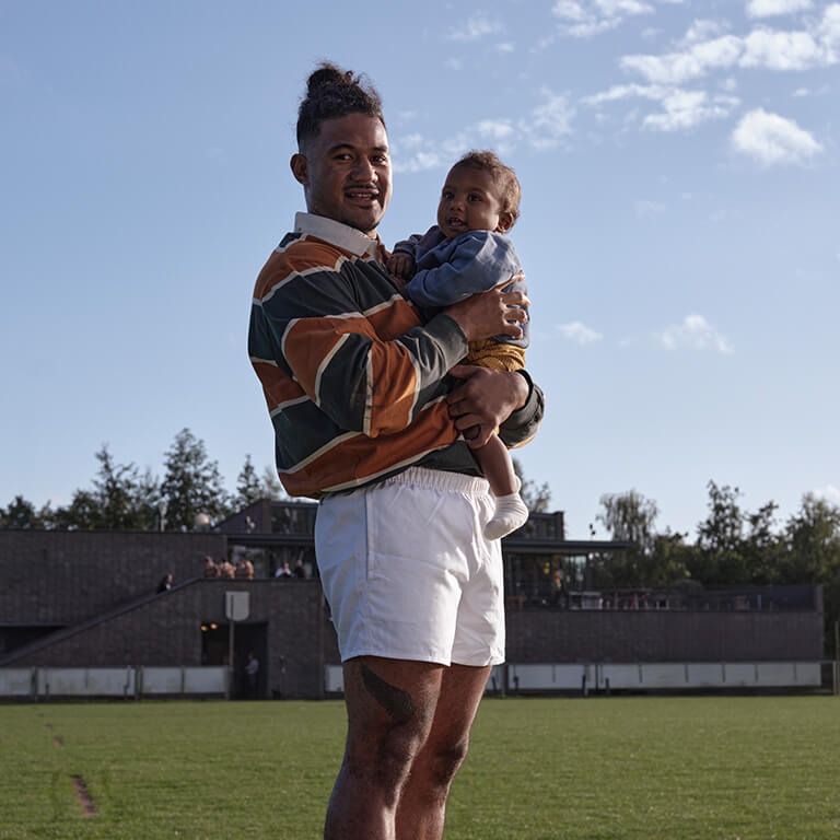 Man knuffelt baby buiten in de blauwe lucht