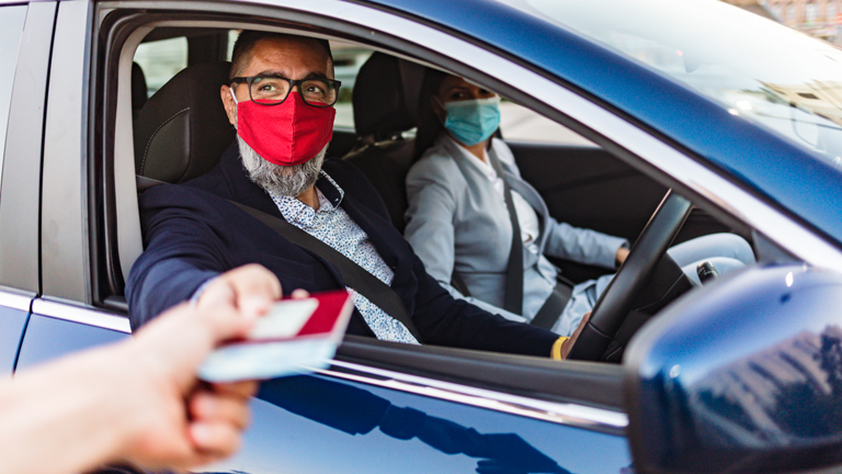 Man and woman in the car handing over the passports at a checkpoint