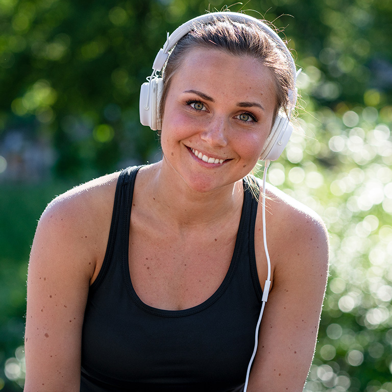 Person wearing headphones sits in the sunshine
