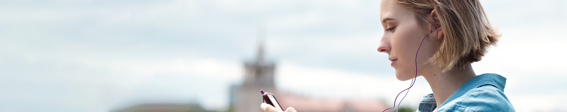 Jonge vrouw luistert muziek via haar smartphone