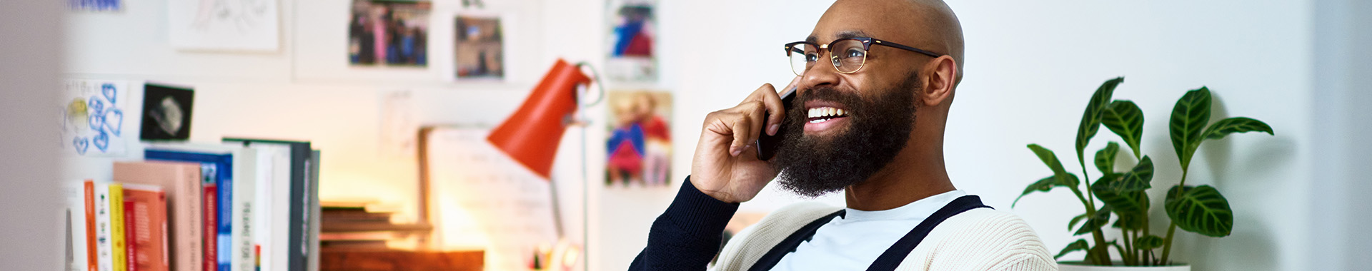 Man met baard lacht aan de telefoon