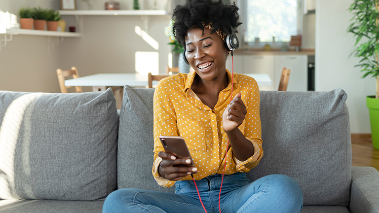 Vrouw op de bank en luist naar muziek