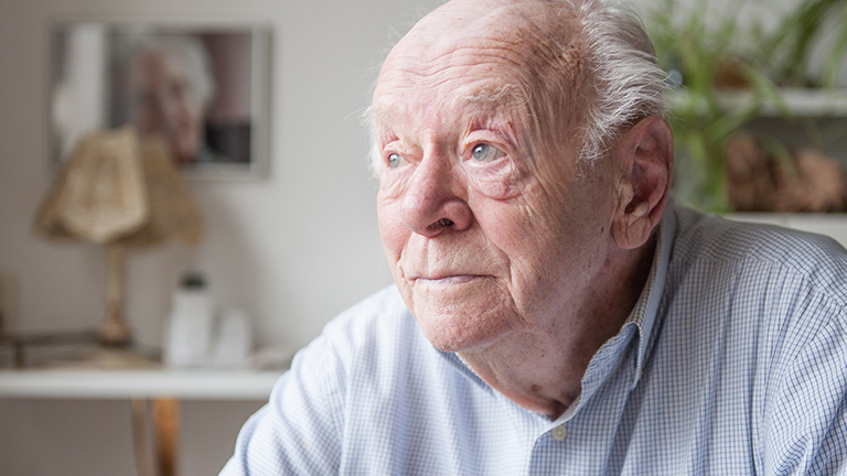 Oudere man staart voor zich uit