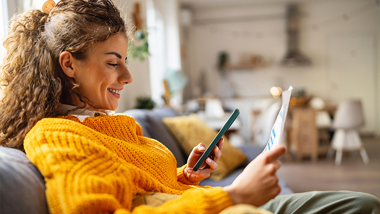 Glimlachende vrouw met foto van rekening met telefoon