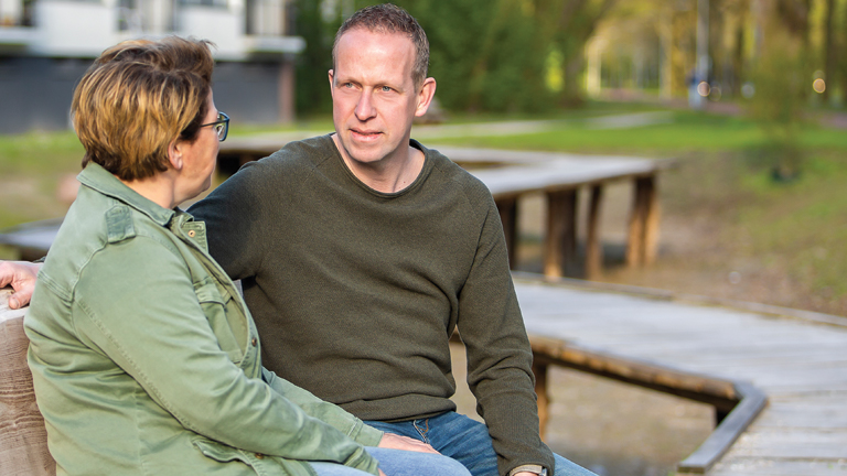 Twee personen op een bankje praten met elkaar